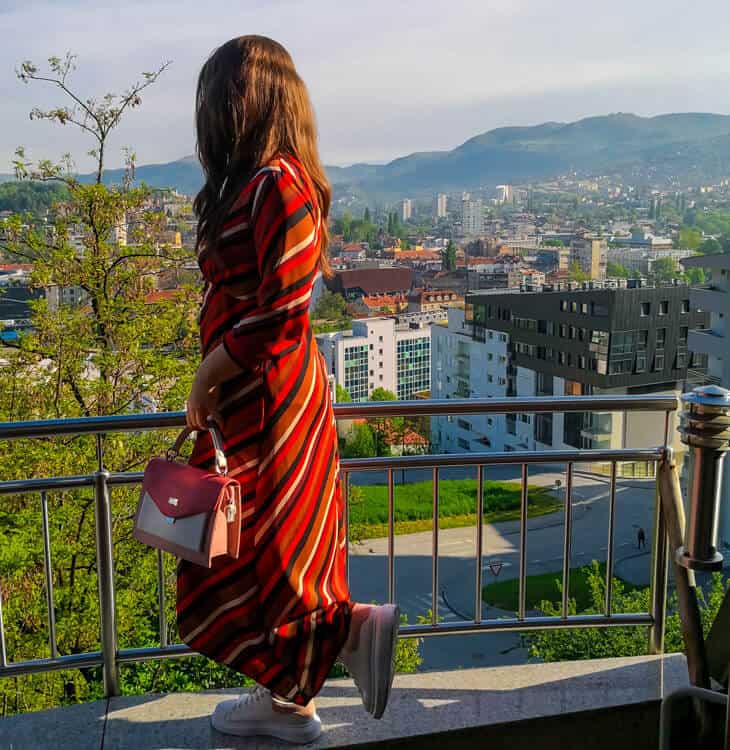 Girl standing at balcony and looking at Sarajevo
