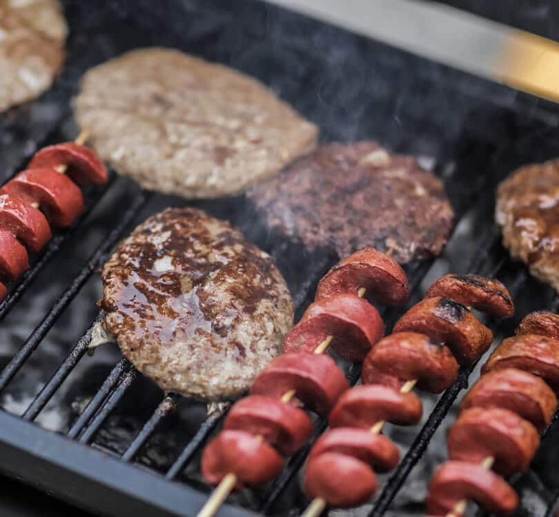 Sausages and hamburgers cooking on BBQ