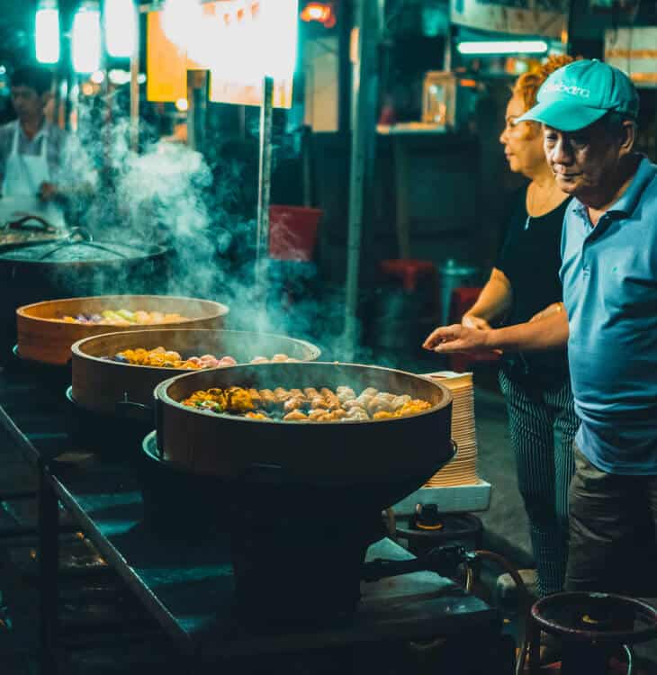 People cooking food at street market in Kuala Lumpur