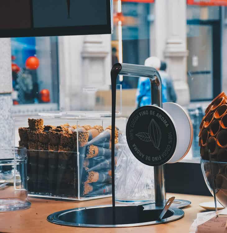 Chocolate flowing from pipe next to ice cream cones in Milan
