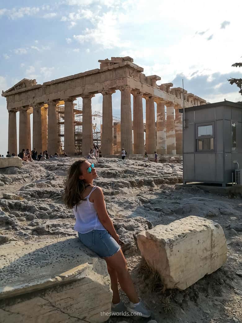 Girl sitting on a rock in from of Parthenon in Athens