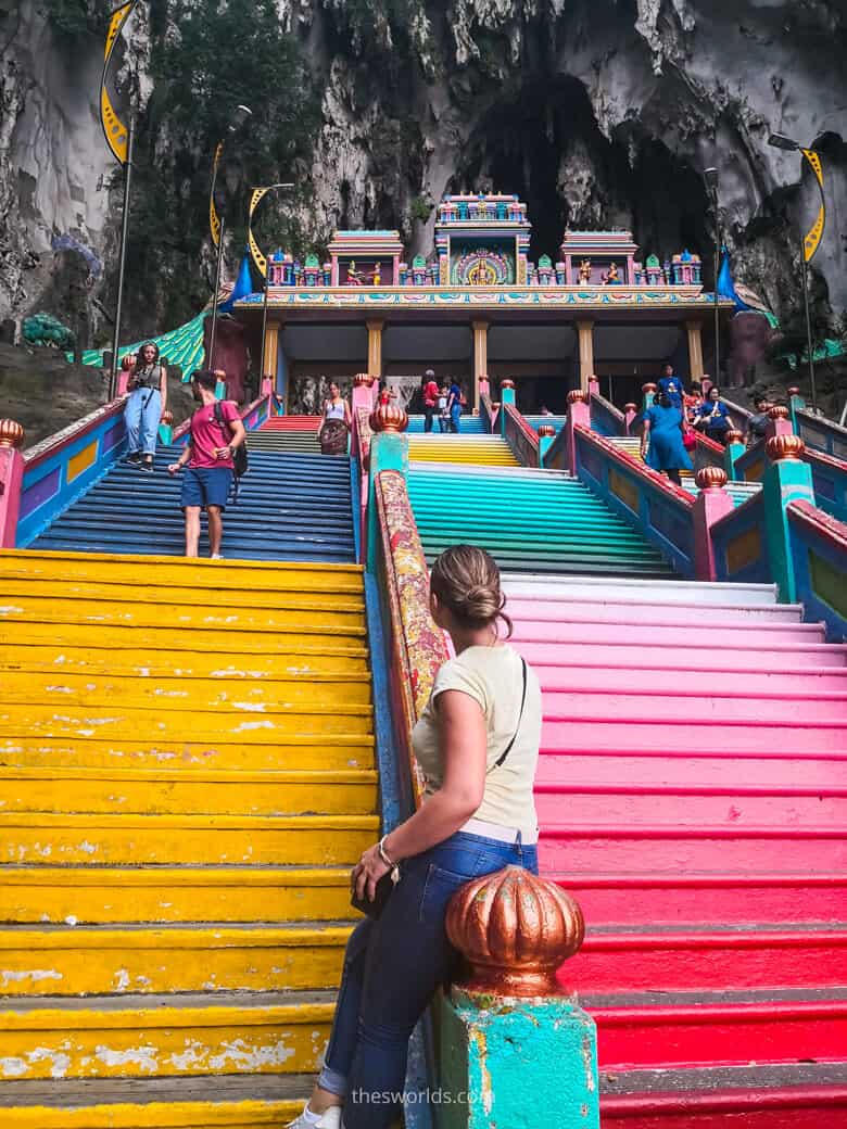 Girl sitting on stairs at entrance to Batu Caves in Kuala Lumpur