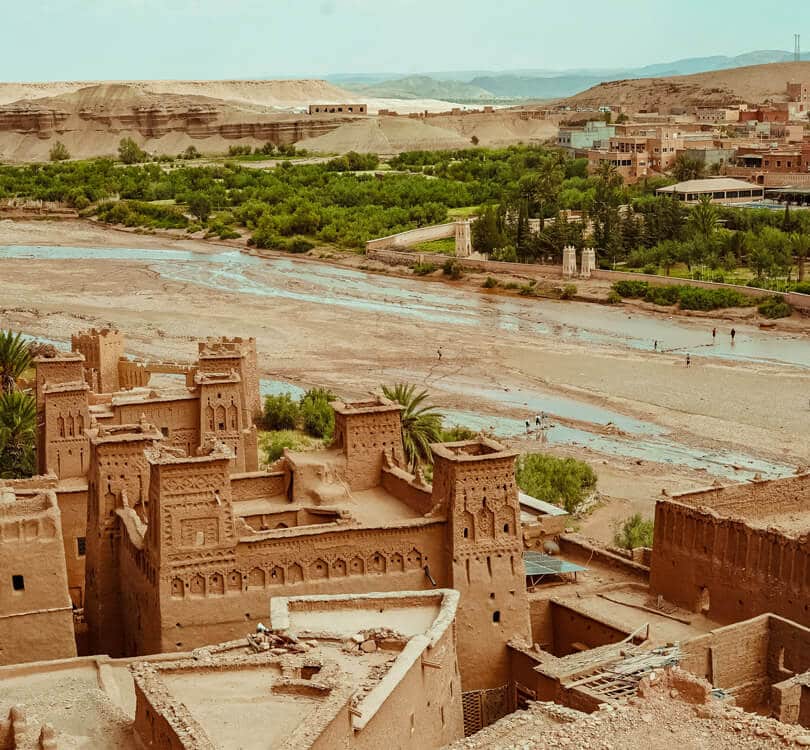 Old morocco building next to river with people