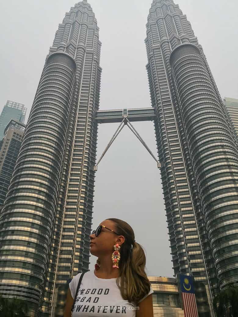 Girl standing in front of Petronas twin towers in Kuala Lumpur