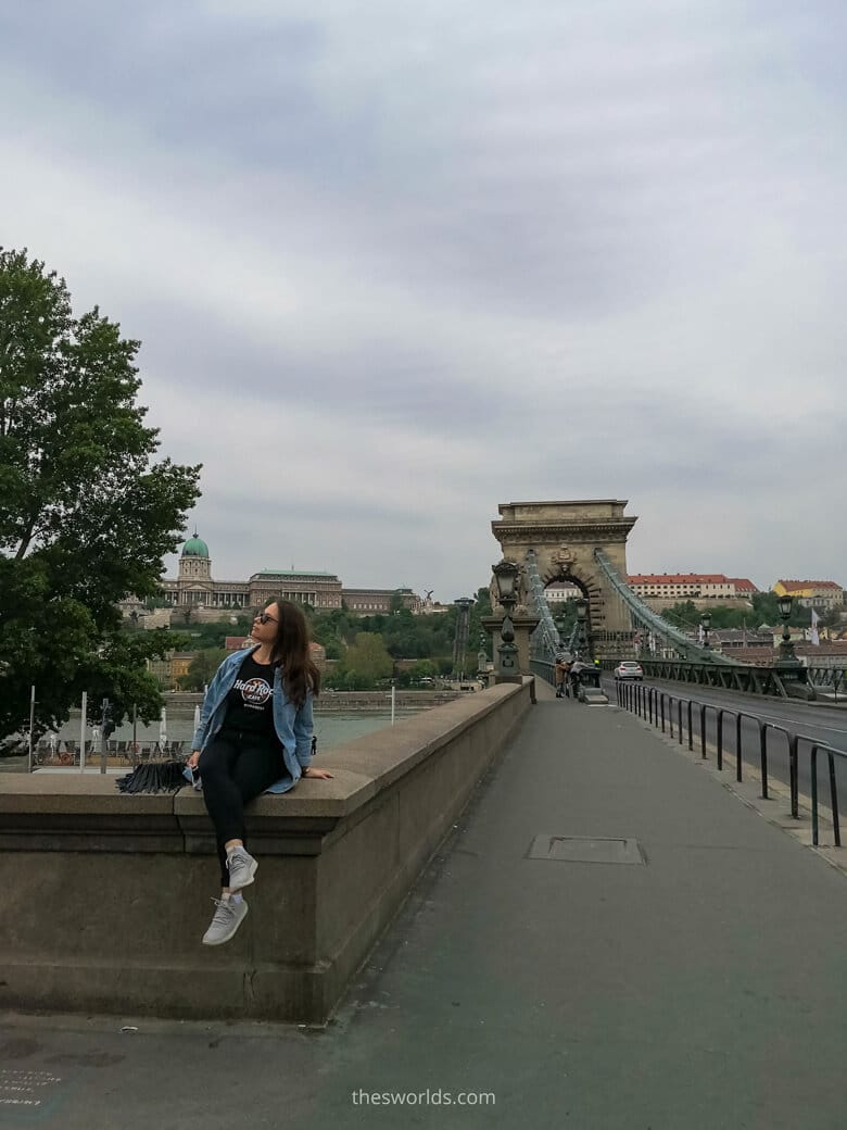 Girl sitting on Szechenyi Chain Bridge in Budapest