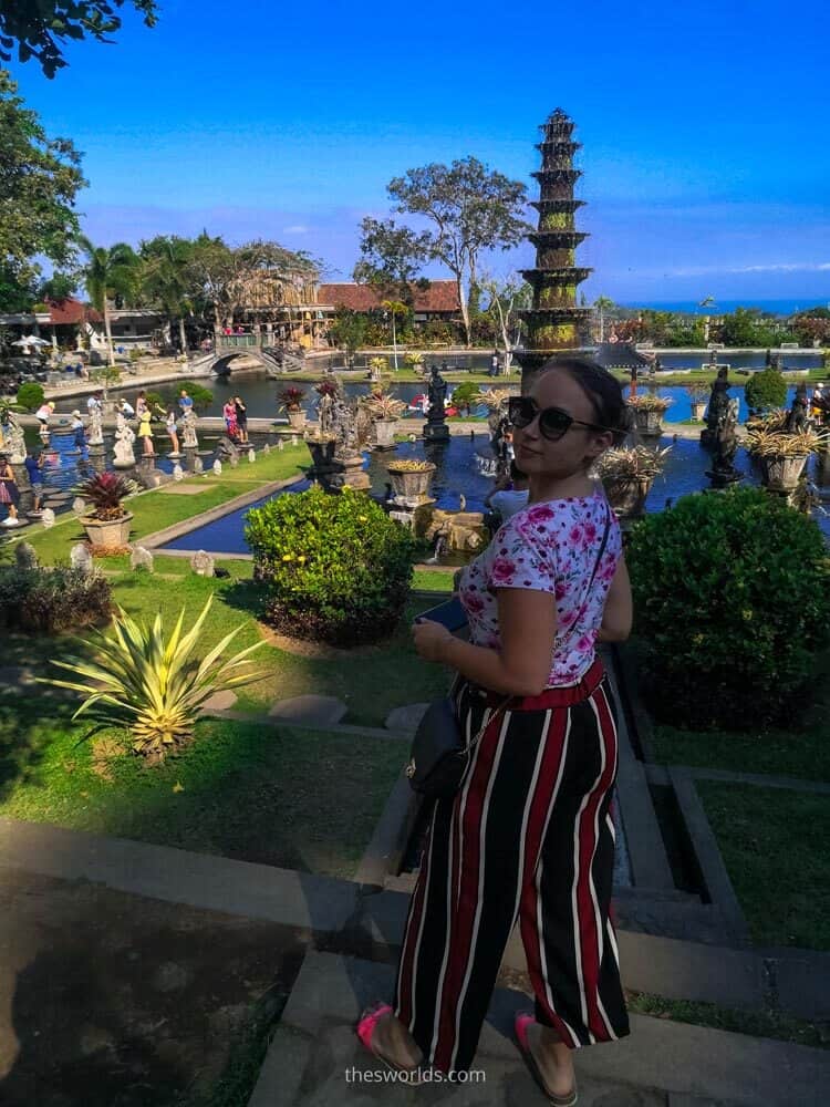 Girl posing at Taman Tirtagangga temple at Bali with fountain in the background