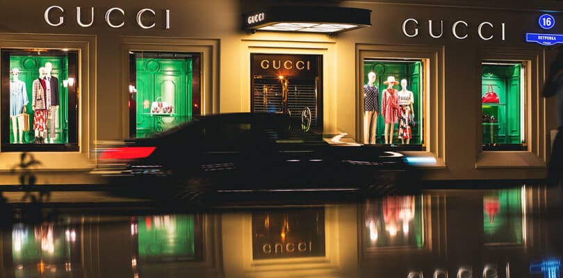 Gucci entrance at night with car passing