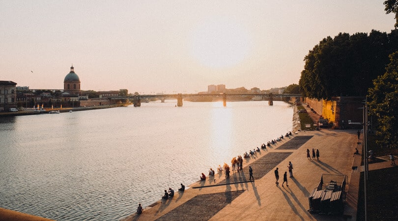 People looking at sunset at Toulouse river in France